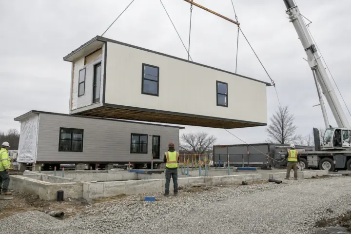 Portable office trailer being positioned at a prepared project site