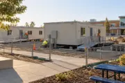 Portable classrooms being installed with accessible ramps on a school campus